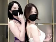 Dos hermosas chicas asiáticas con máscaras bailan